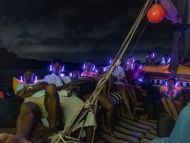 Audience wearing illuminated headphones during a night screening aboard a dhow